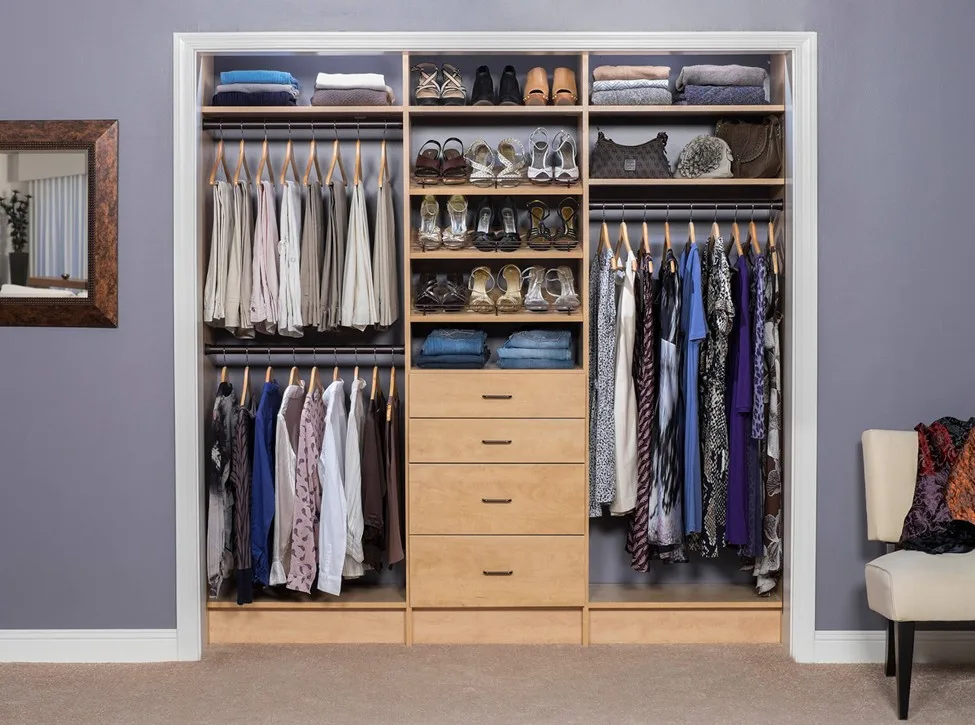 Neatly organized reach-in closet with hanging clothes, shoe racks, drawers, and folded items